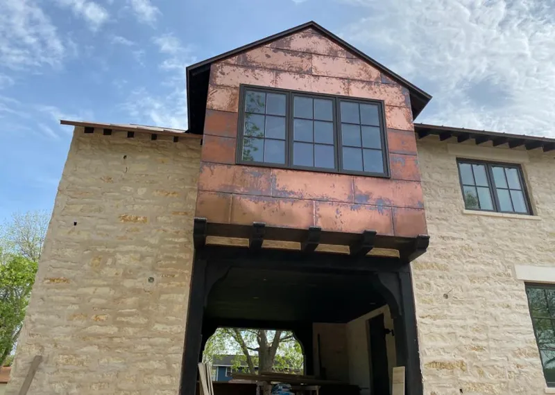 Copper metal panel facade on a stone building for Roof Repair in Cherokee Village